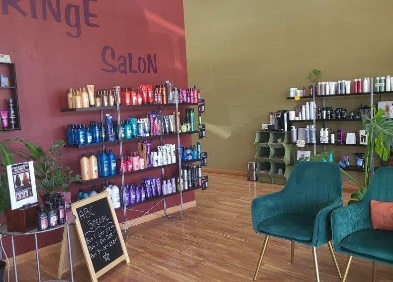 Fringe Salon in Elkhart, Indiana, US, showcasing chic seating and diverse hair care products on wooden shelves.