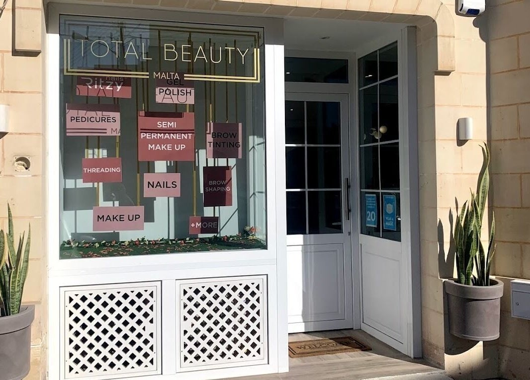 Front entrance of Total Beauty Malta, Ħal Luqa, MT, showcasing beauty services signage and decor.