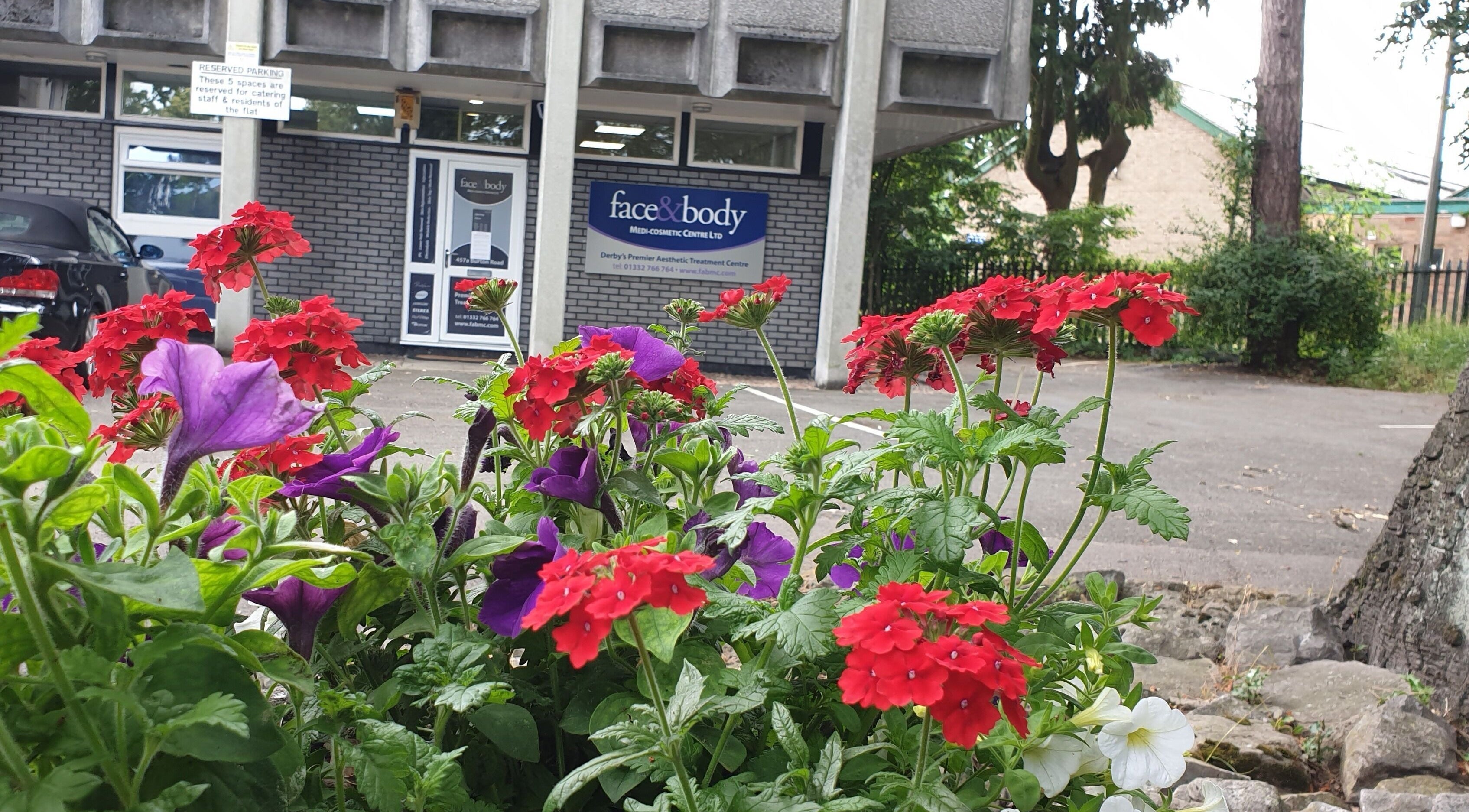 Face & Body Medi-cosmetic Centre entrance with vibrant flowers in Derby, England, GB.