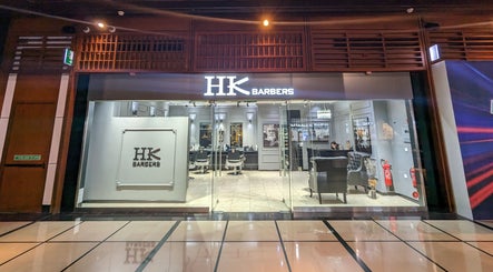 Front view of Hk Barbers at WTC Mall AD, Abu Dhabi. Modern interior with chairs and decor.