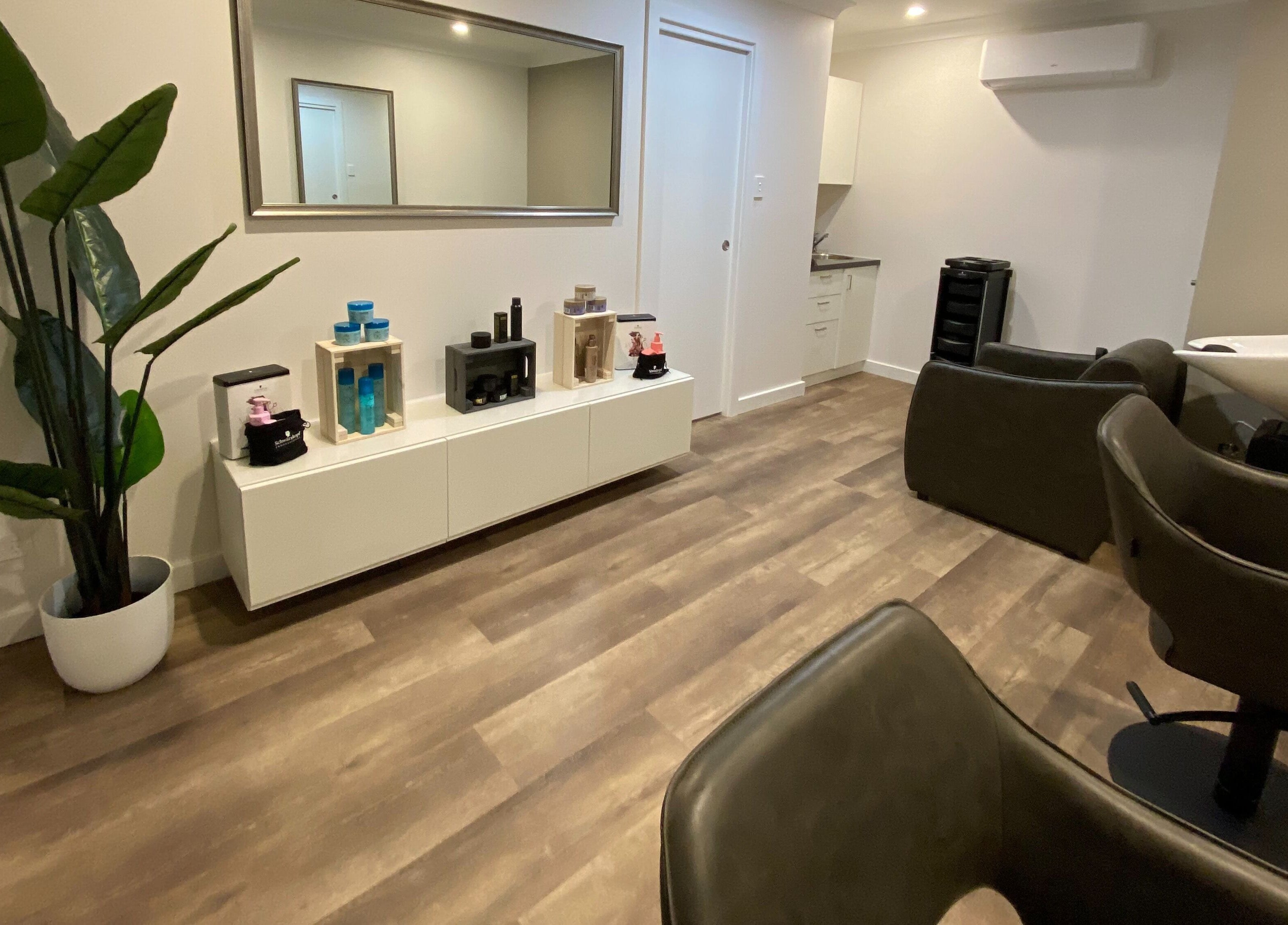 Modern salon interior at Hair at HQ, Menai, New South Wales, AU with stylish chairs and hair products.