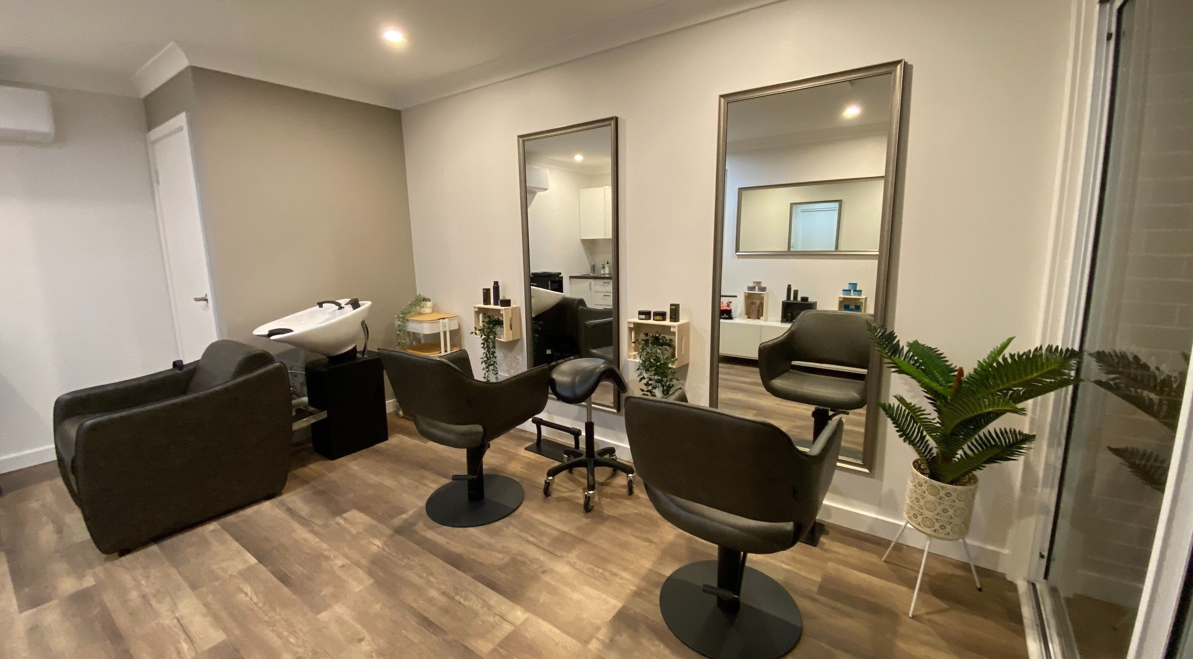 Modern salon interior at Hair at HQ, Menai, New South Wales, AU featuring stylish chairs and mirrors.