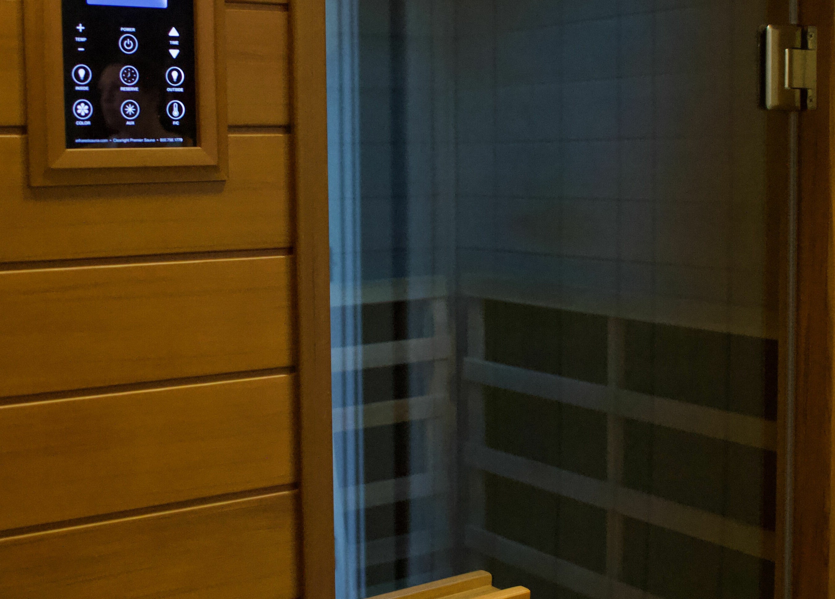Modern sauna room at Konza Saunas in Manhattan, Kansas, US, featuring wooden paneling and a digital control panel.