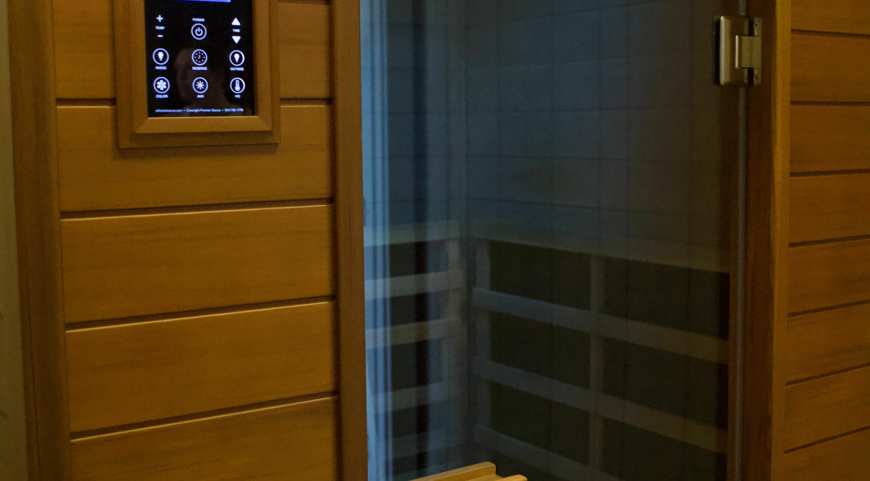 Modern sauna room at Konza Saunas in Manhattan, Kansas, US, featuring wooden paneling and a digital control panel.
