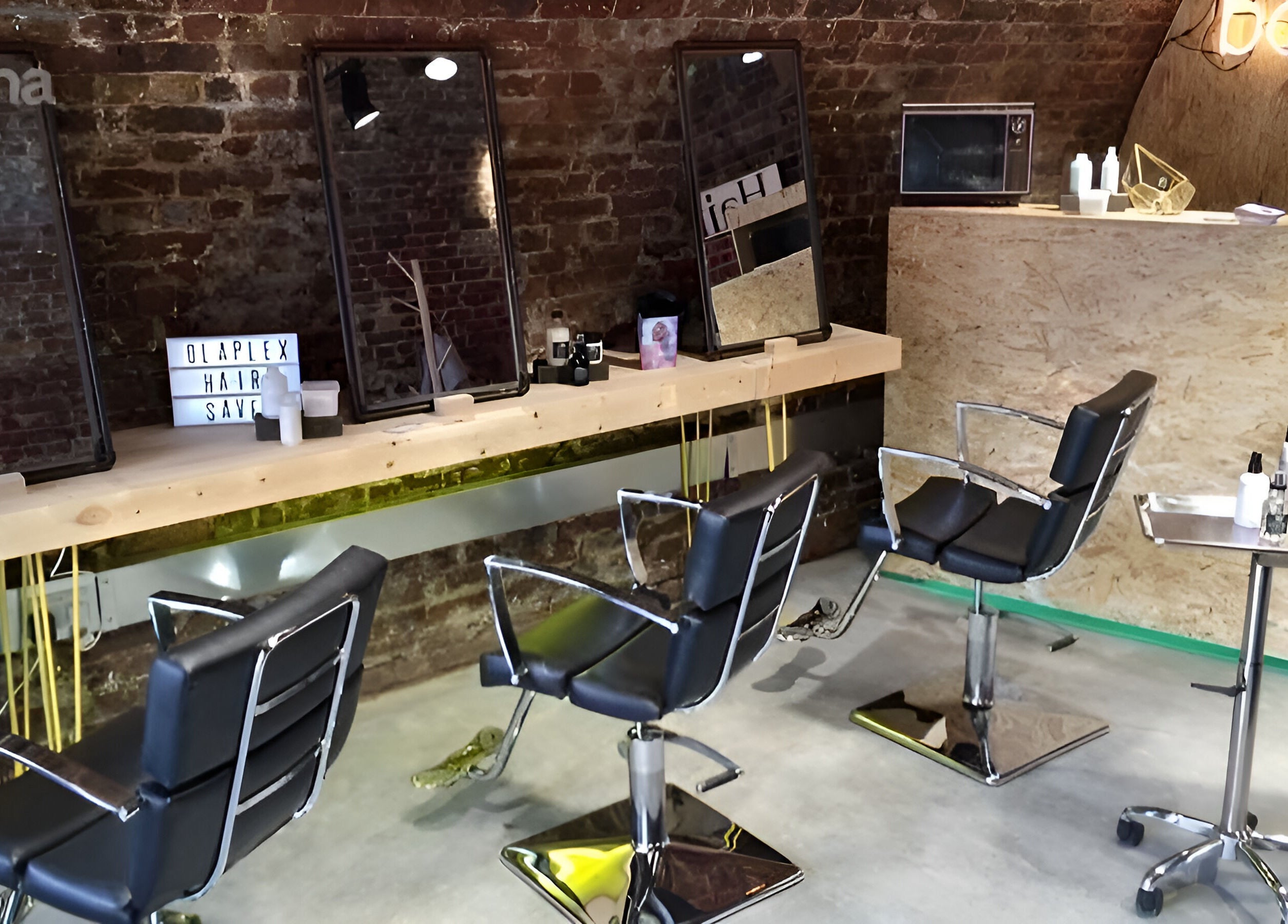 Stylish interior of The Box Hair Salon Deptford, London, England, GB with modern chairs and mirrors.