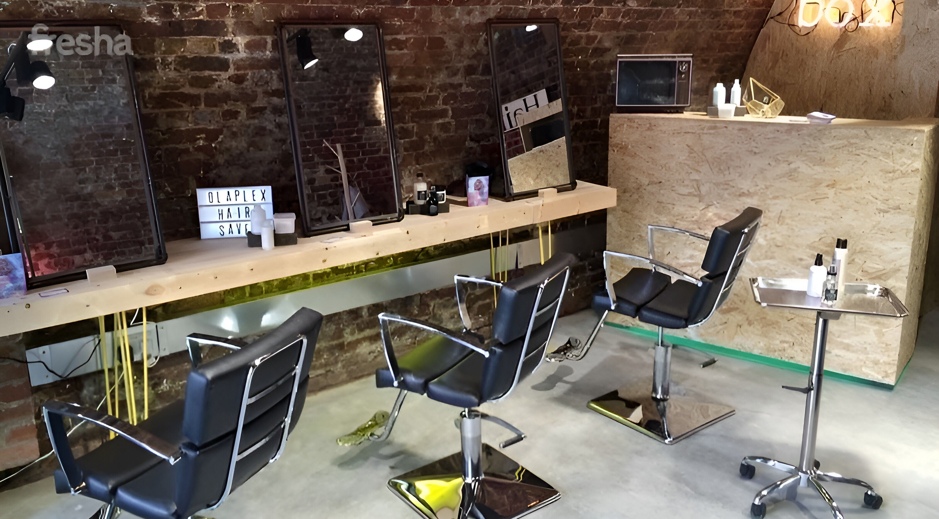 Stylish interior of The Box Hair Salon Deptford, London, England, GB with modern chairs and mirrors.