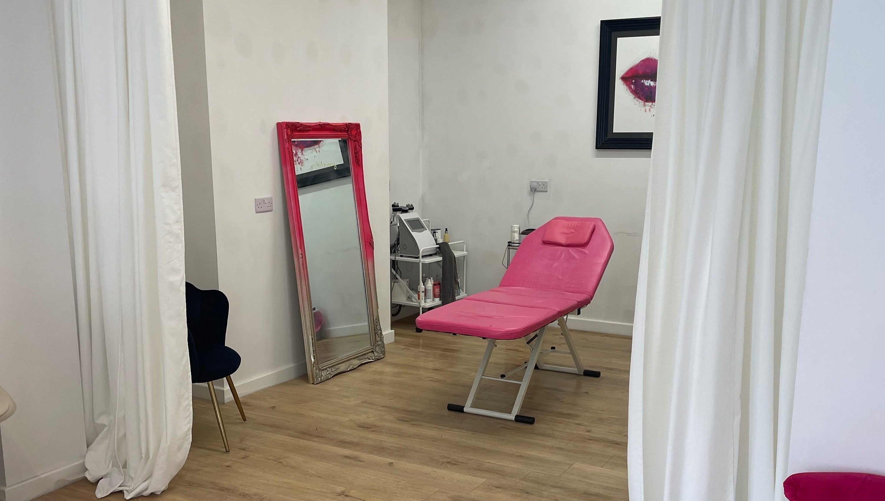 Modern beauty room at Beauty Junkie, Jarrow, England with pink treatment chair and elegant decor.