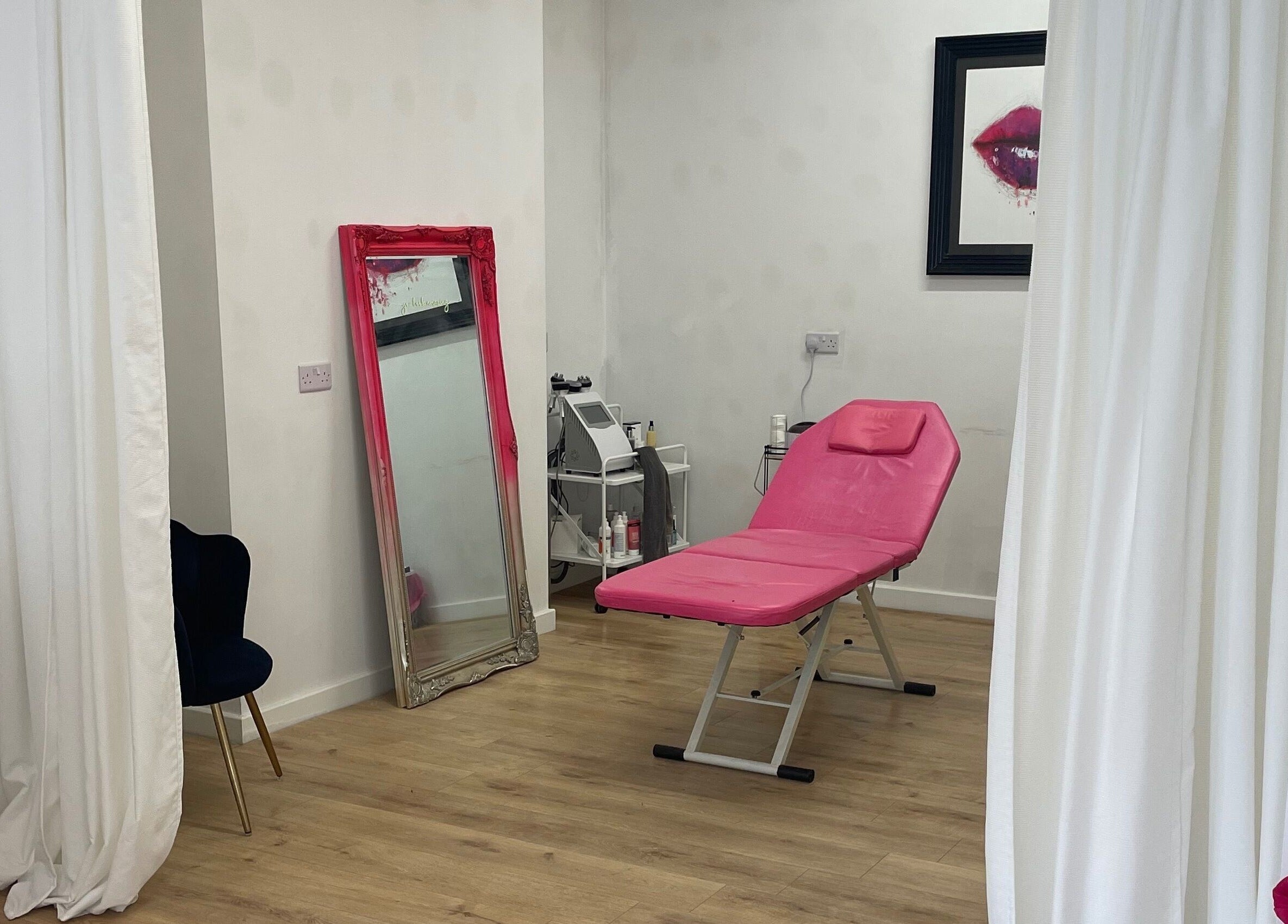 Modern beauty room at Beauty Junkie, Jarrow, England with pink treatment chair and elegant decor.