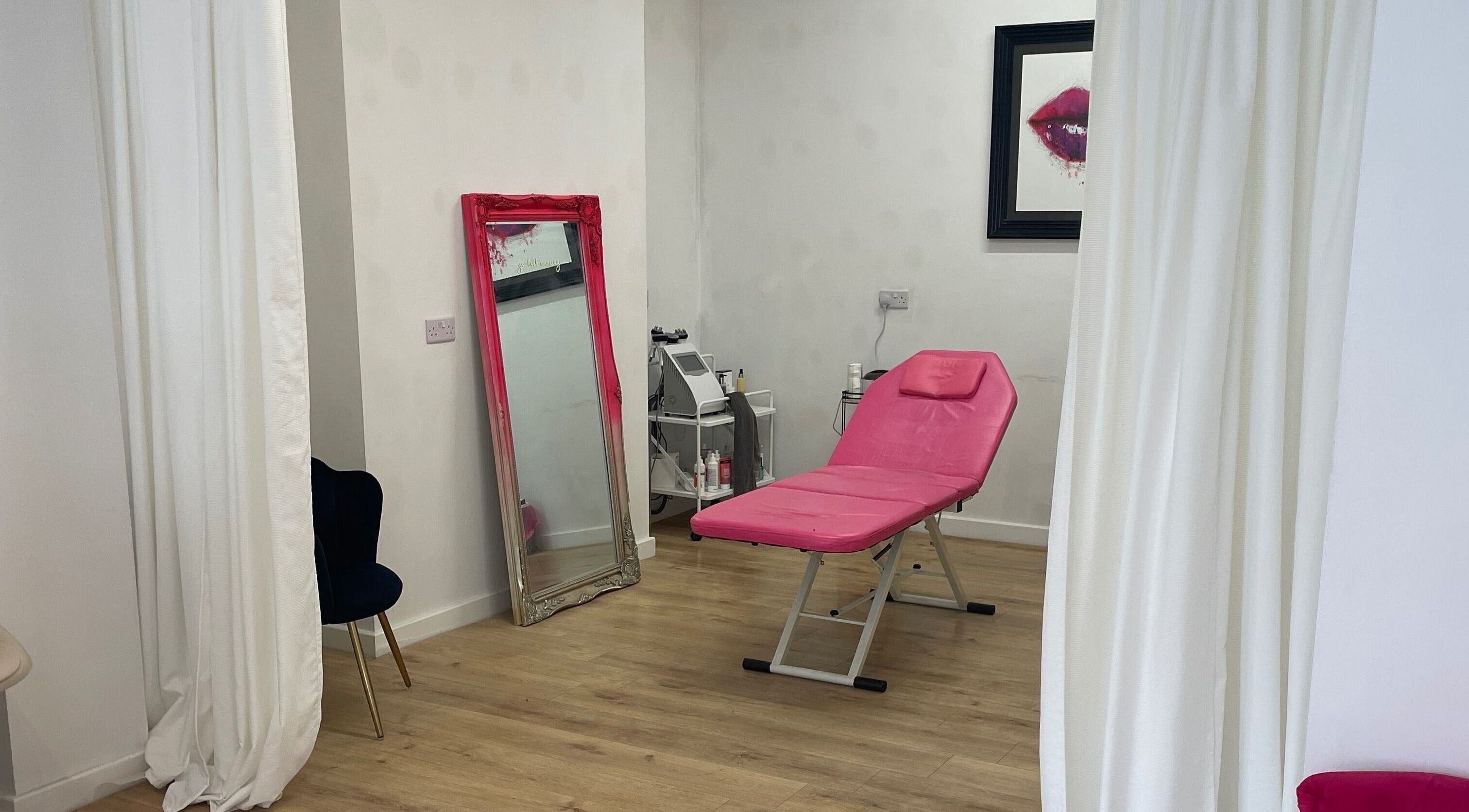 Modern beauty room at Beauty Junkie, Jarrow, England with pink treatment chair and elegant decor.