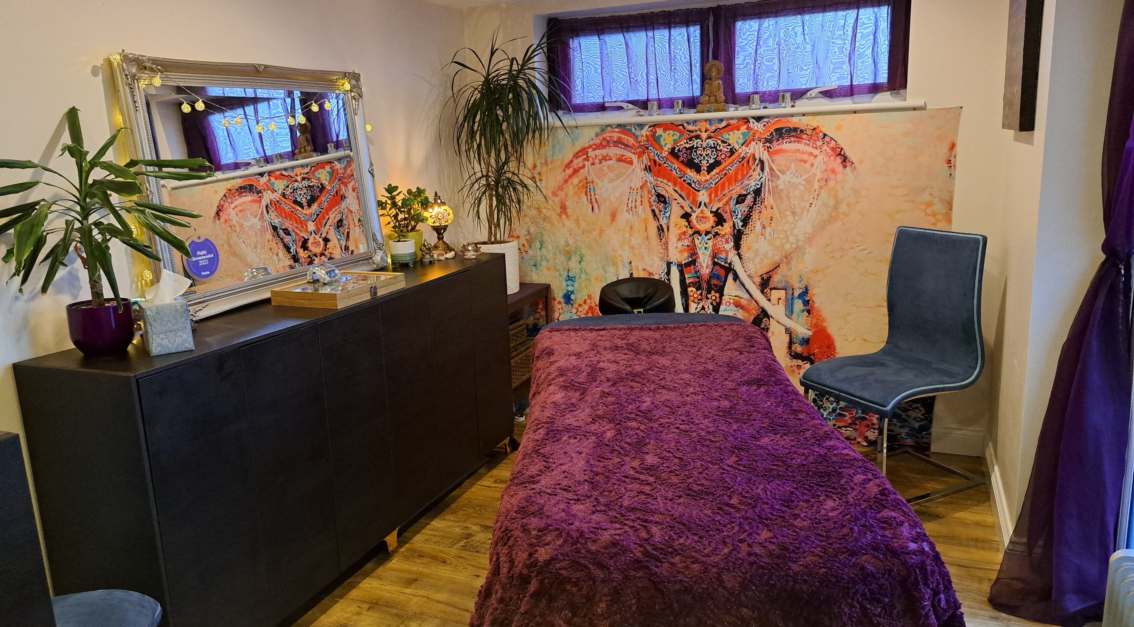 Inviting treatment room at Tranquil Space Holistic Treatments, Bristol, GB, featuring cozy decor and elephant art.