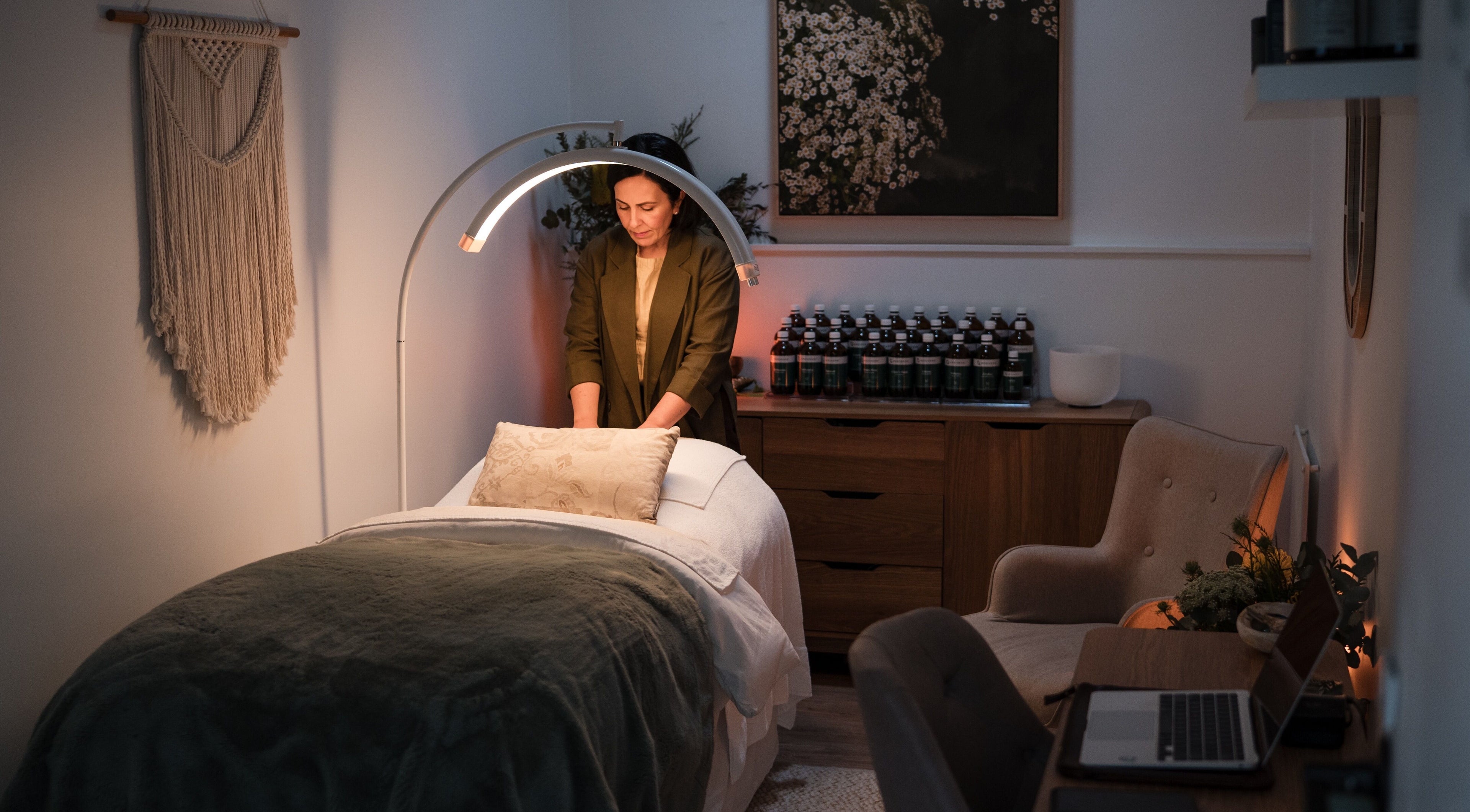 Masseuse preparing serene massage room at Mata Wellbeing, Melbourne, Victoria, AU for a relaxing experience.