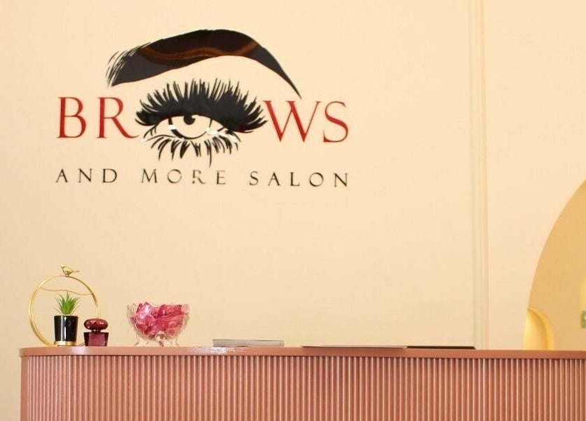 Reception area at Brows and More Salon, Dubai, with elegant decor and logo on display.