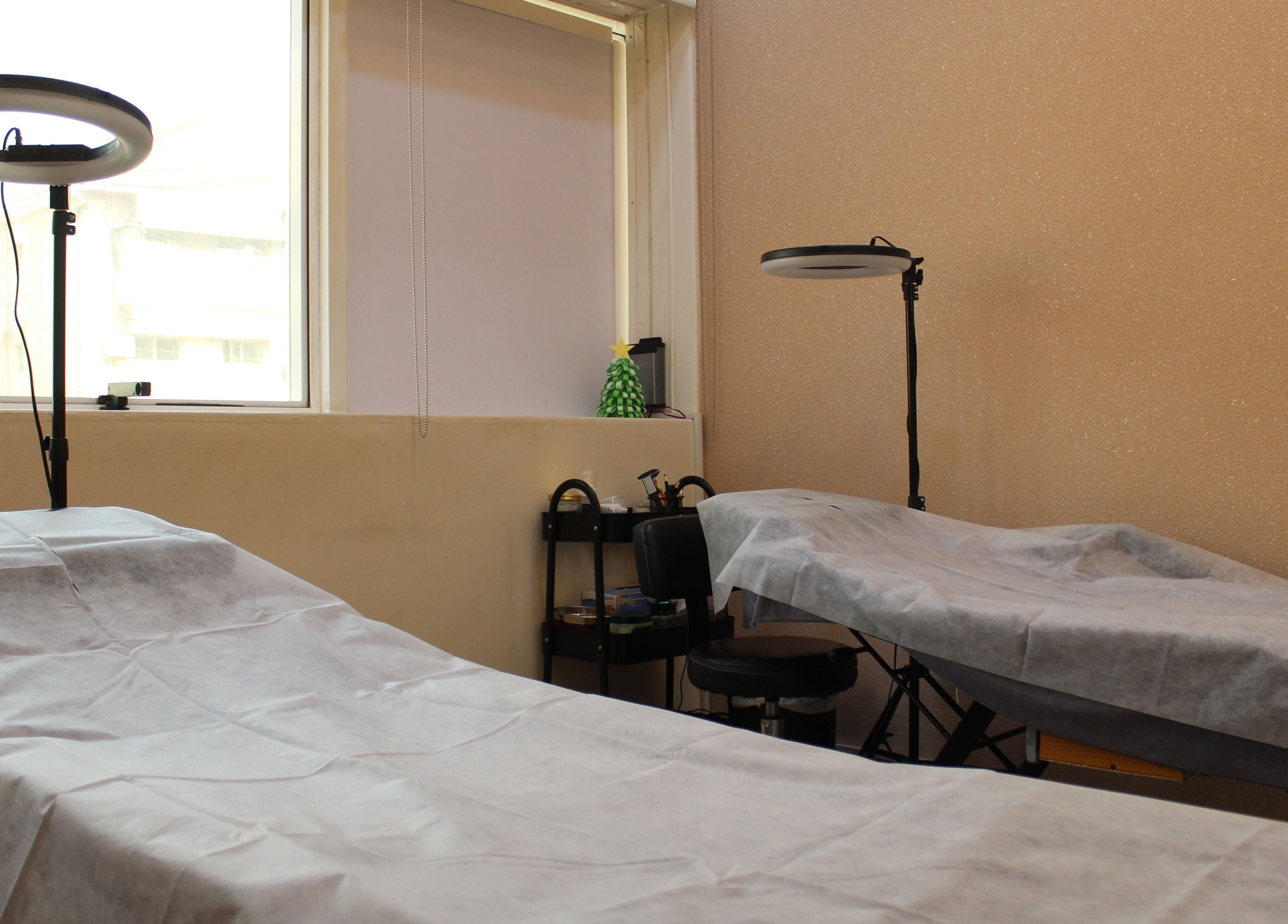 Cozy treatment area at Brows and More (Karama), Dubai, Dubai, AE with two beds and professional lighting.