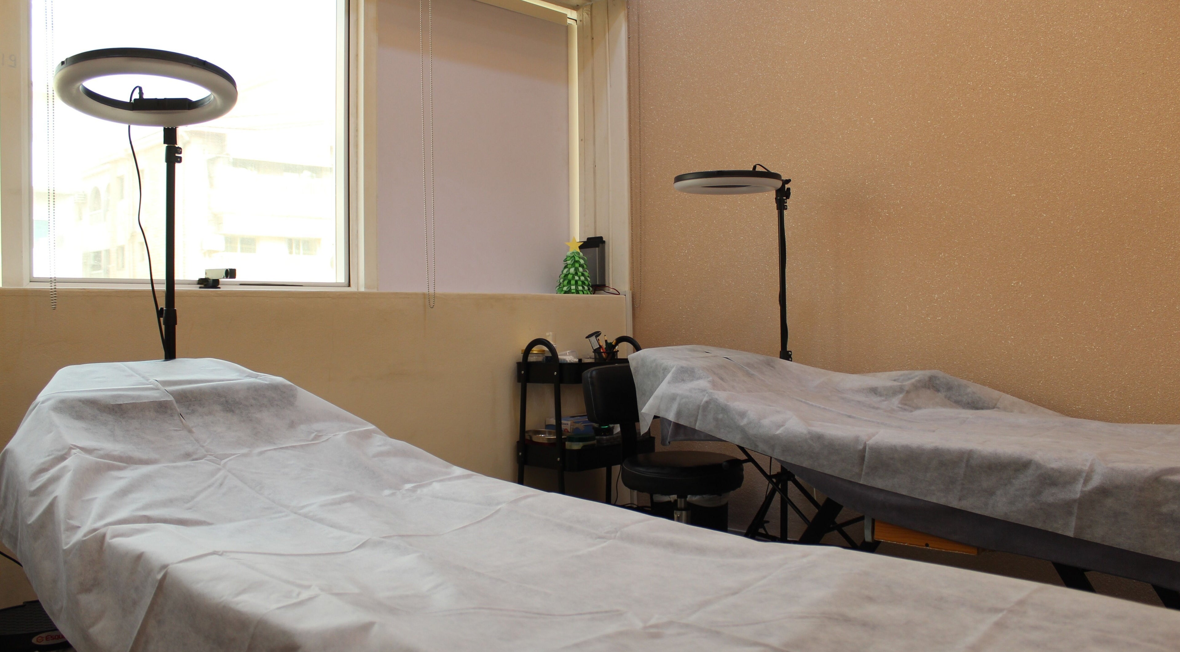 Cozy treatment area at Brows and More (Karama), Dubai, Dubai, AE with two beds and professional lighting.