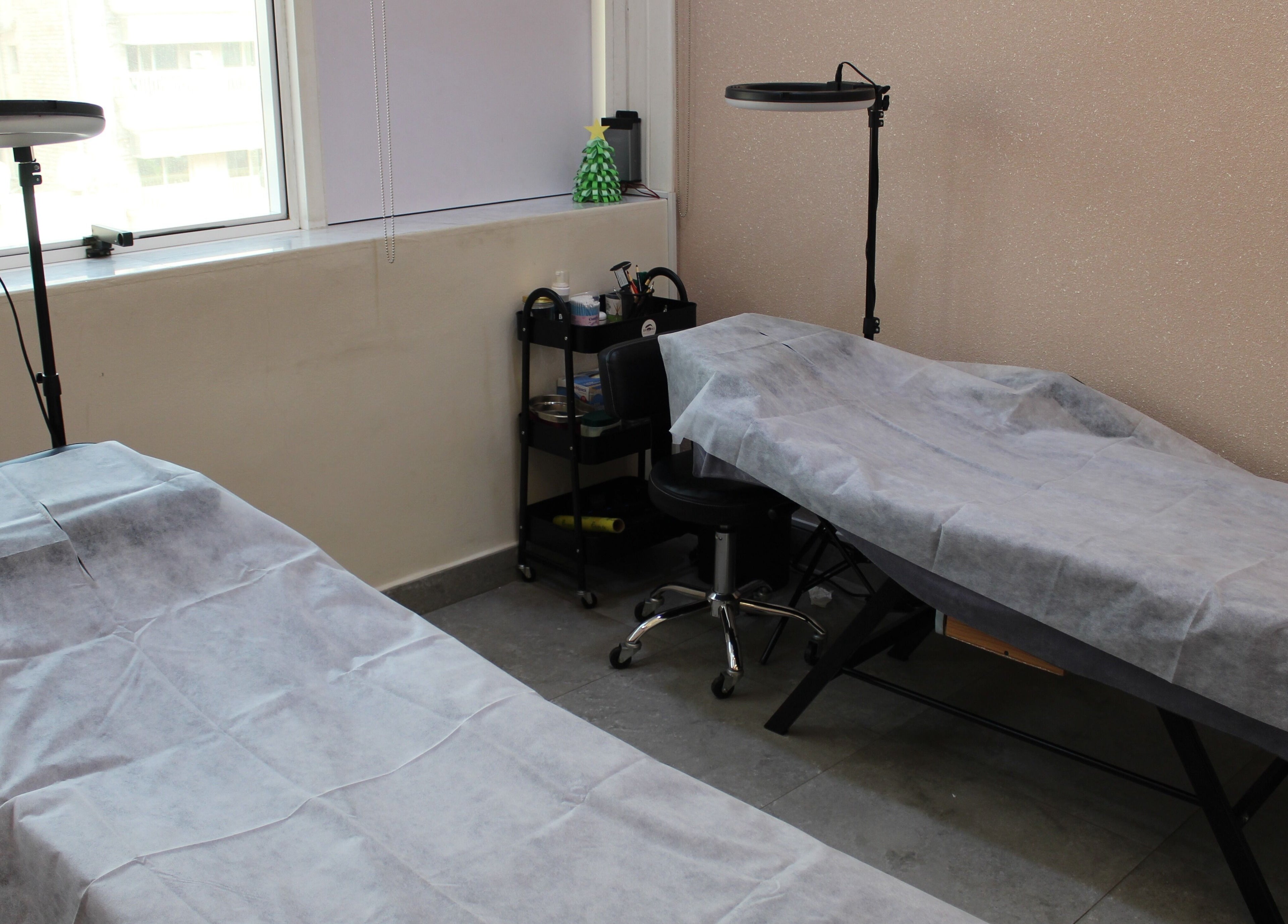 Cozy treatment room at Brows and More (Karama), Dubai, Dubai, AE, featuring two covered massage tables.