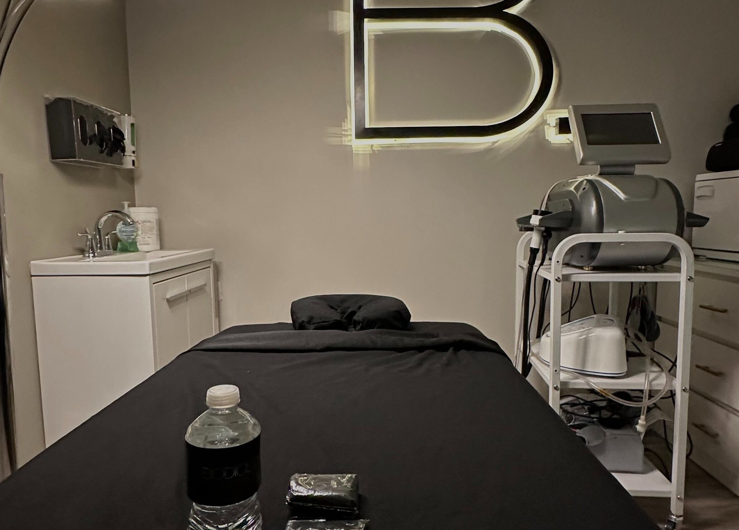Modern treatment room at Bodiology Aesthetics, Calgary, Alberta, CA with equipment and a comfortable bed.