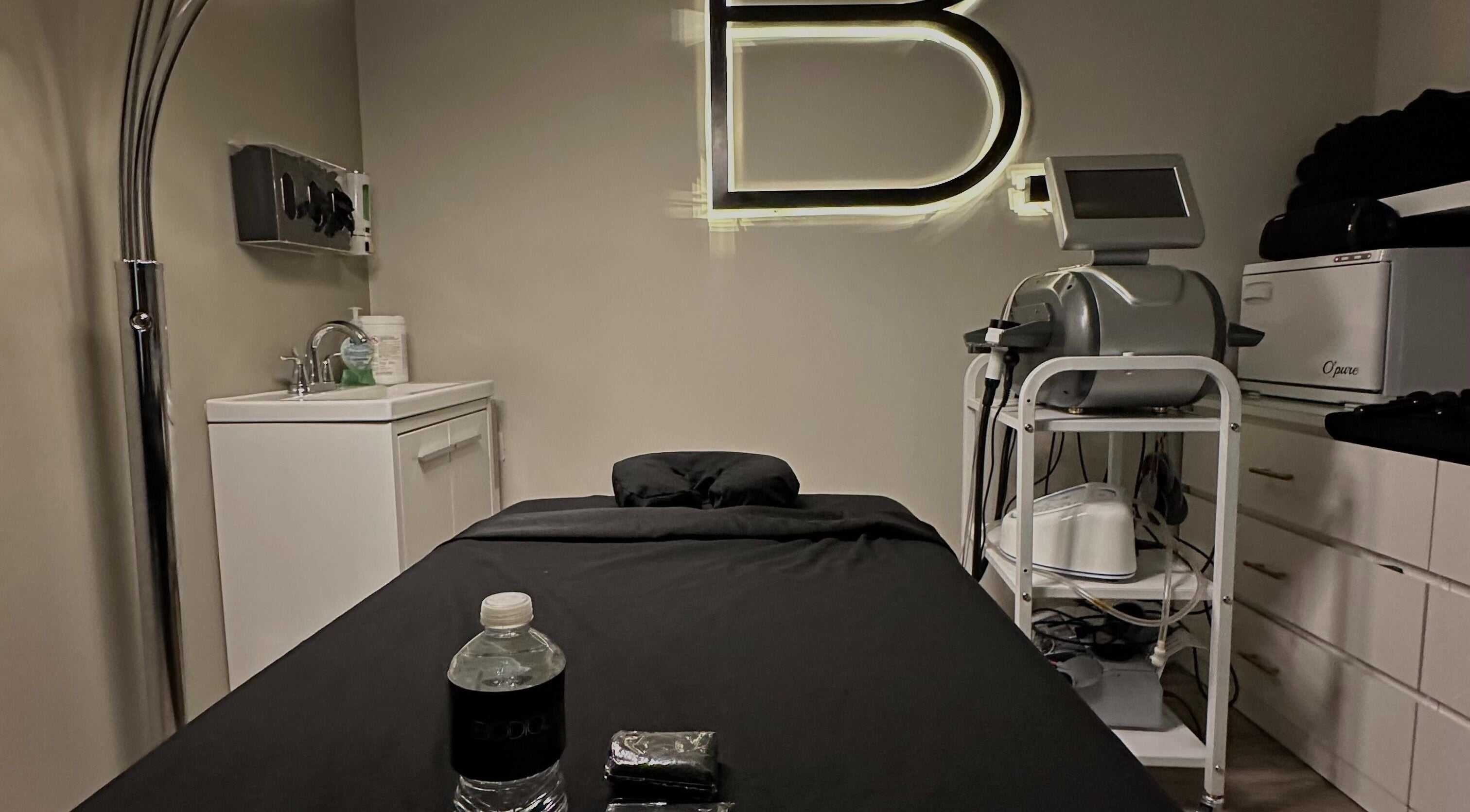 Modern treatment room at Bodiology Aesthetics, Calgary, Alberta, CA with equipment and a comfortable bed.