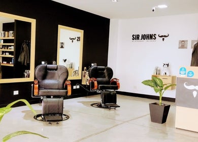 Interior moderno de Sir Johns El Punto Shopping en San Lorenzo Chico, Salta, AR, con sillas de peluquería y decoración elegante.