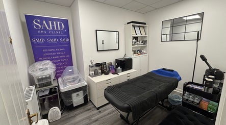 Relaxing treatment room at SAHD Spa Clinic - Stanley, featuring a massage table and skincare products.