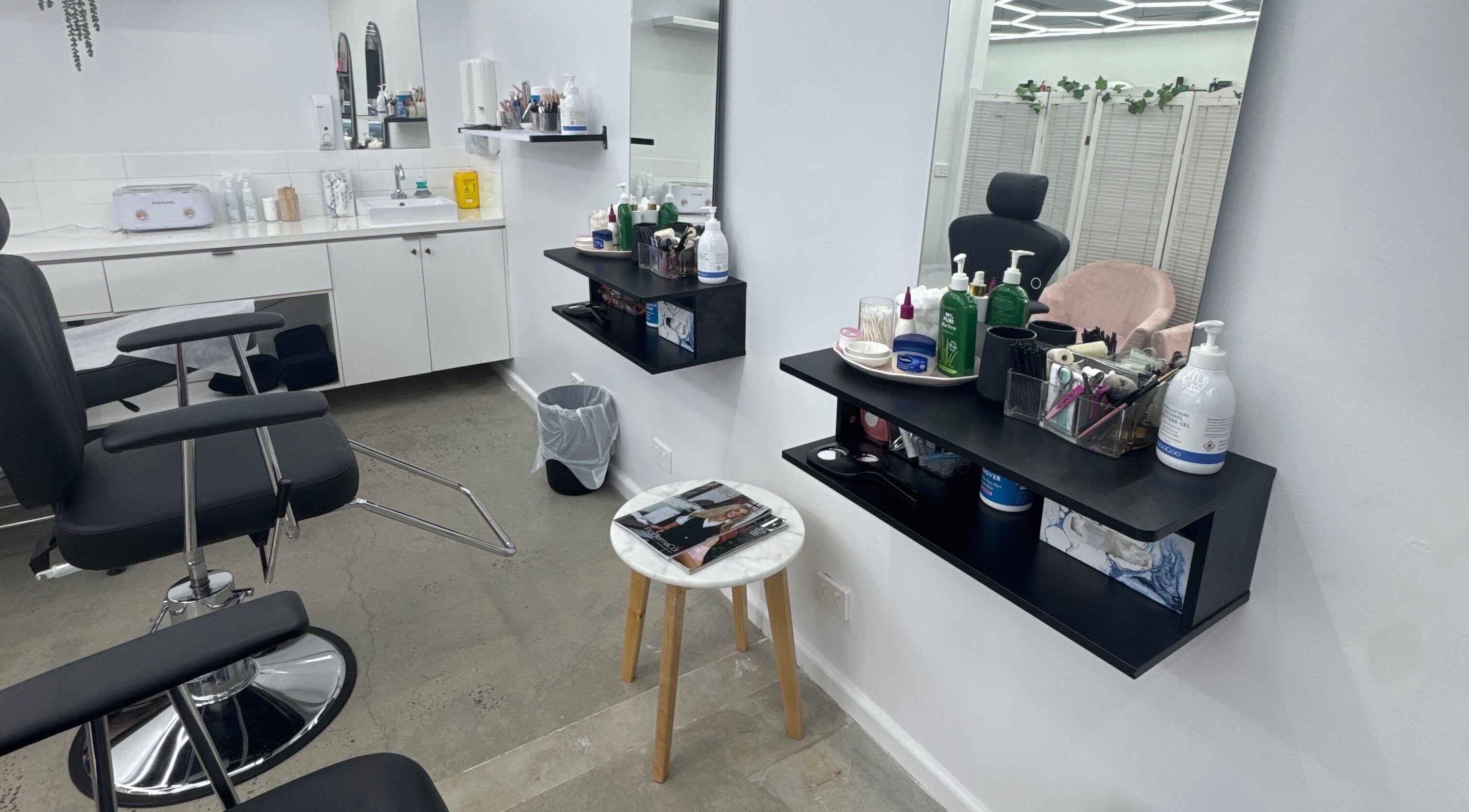 Modern beauty station at Brows by Sonia in Melbourne, Victoria, AU with chairs, mirrors, and products.