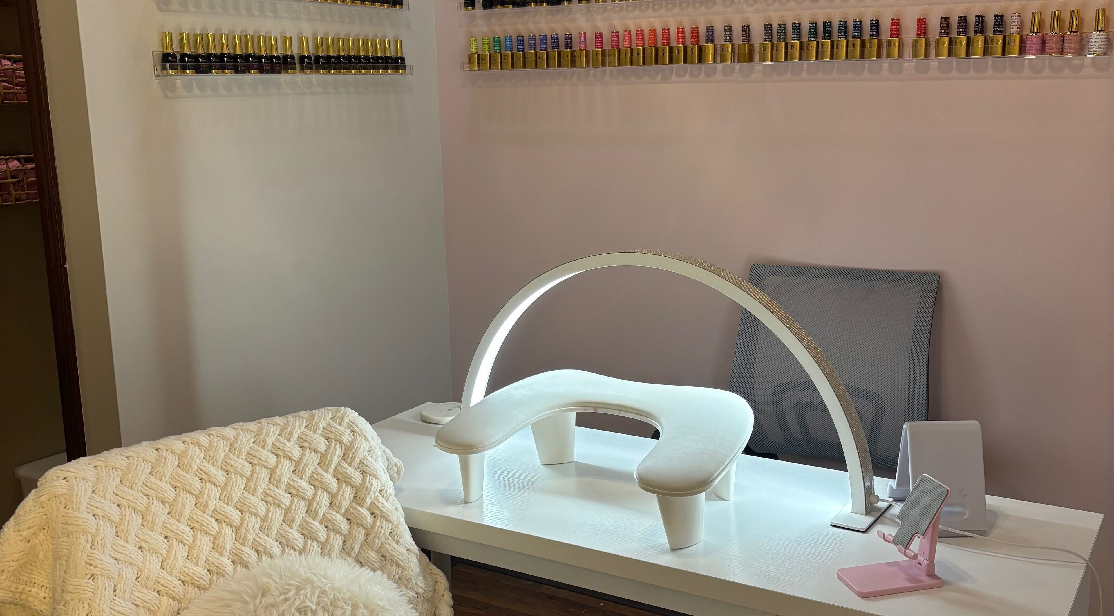 Cozy manicure station at Nails by Elsa in Davenport, Iowa, US, showcasing a range of vibrant nail polishes.