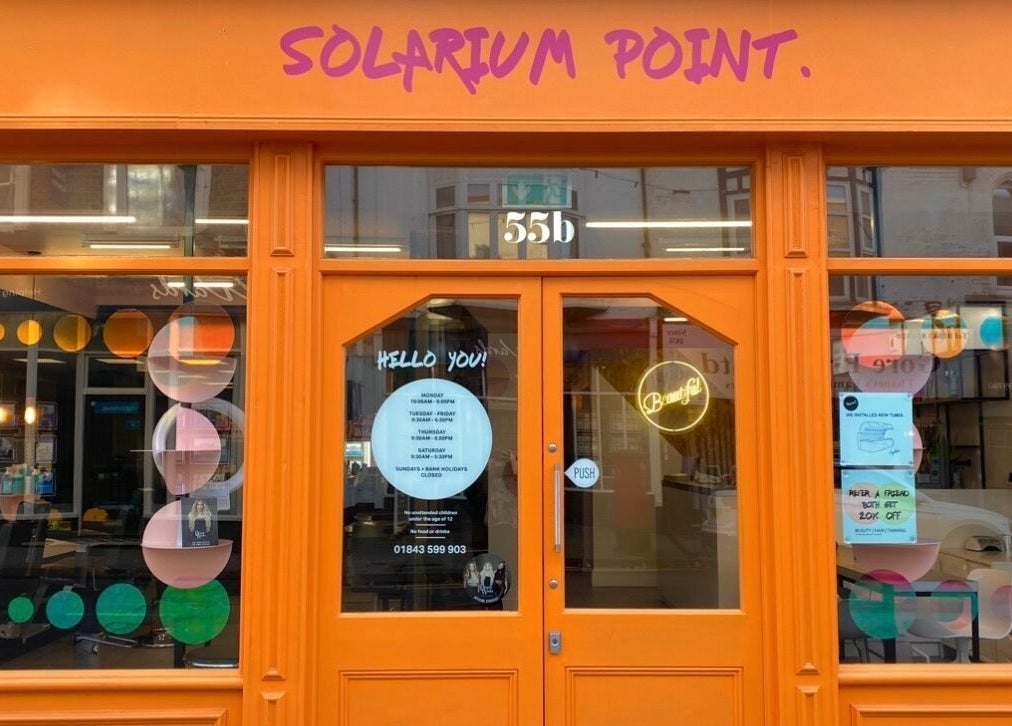 Bright orange storefront of Solarium Point in Ramsgate, England, GB with playful window designs.