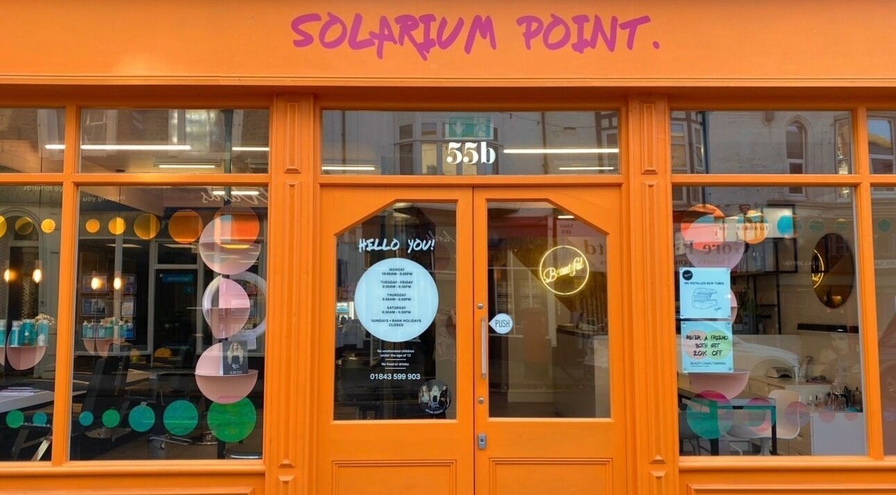 Bright orange storefront of Solarium Point in Ramsgate, England, GB with playful window designs.
