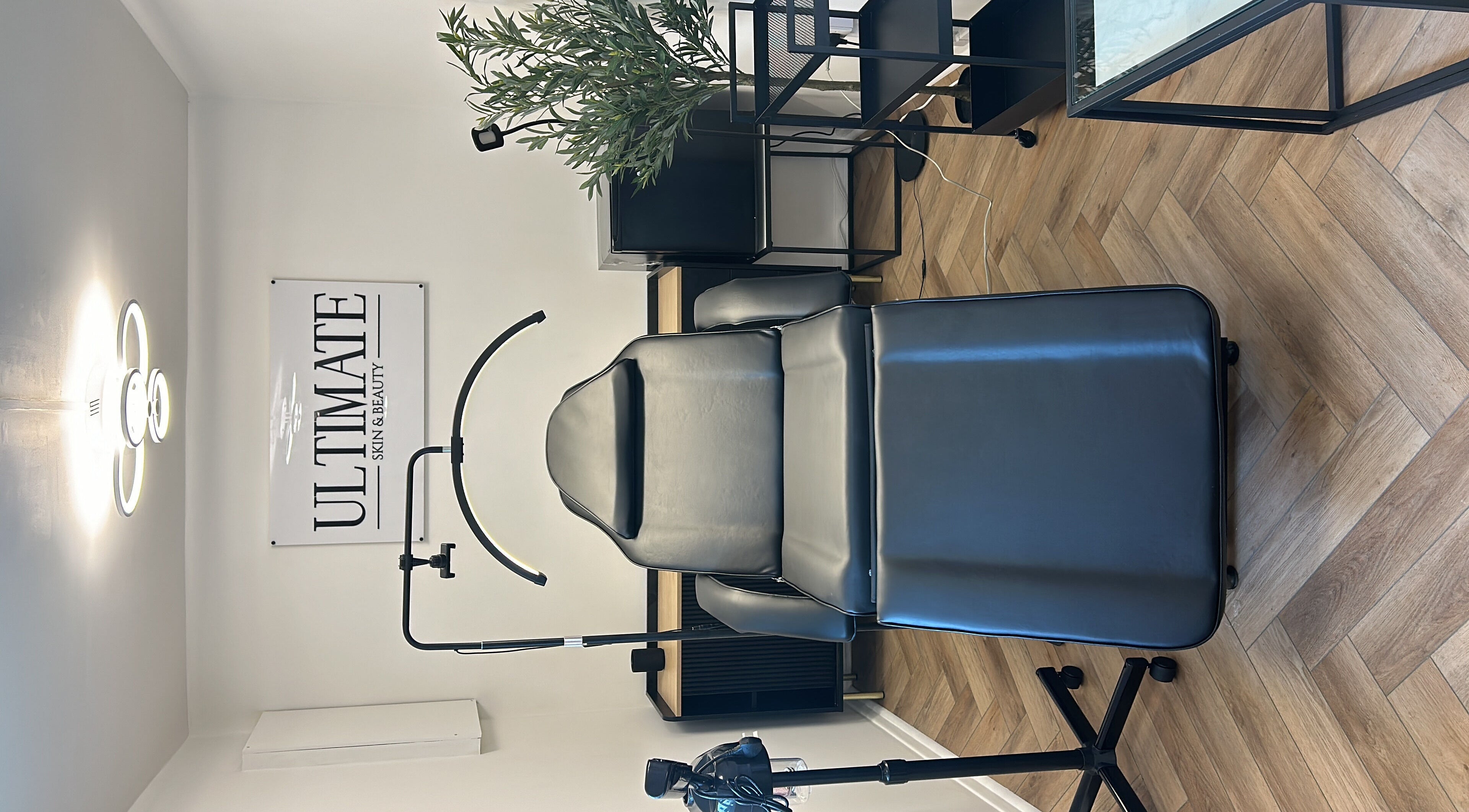 Luxury treatment room at Ultimate Skin and Beauty - Kent, Bexleyheath, England, with a stylish black chair.