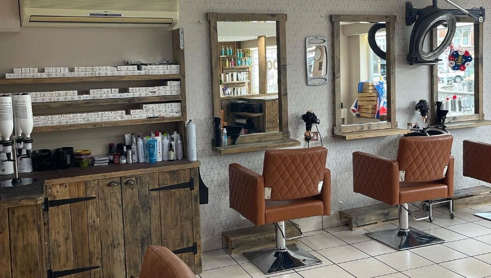Cozy interior of Cocoa Hair Design in Keynsham, England, showcasing stylish chairs and wall-mounted mirrors.