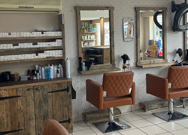 Cozy interior of Cocoa Hair Design in Keynsham, England, showcasing stylish chairs and wall-mounted mirrors.