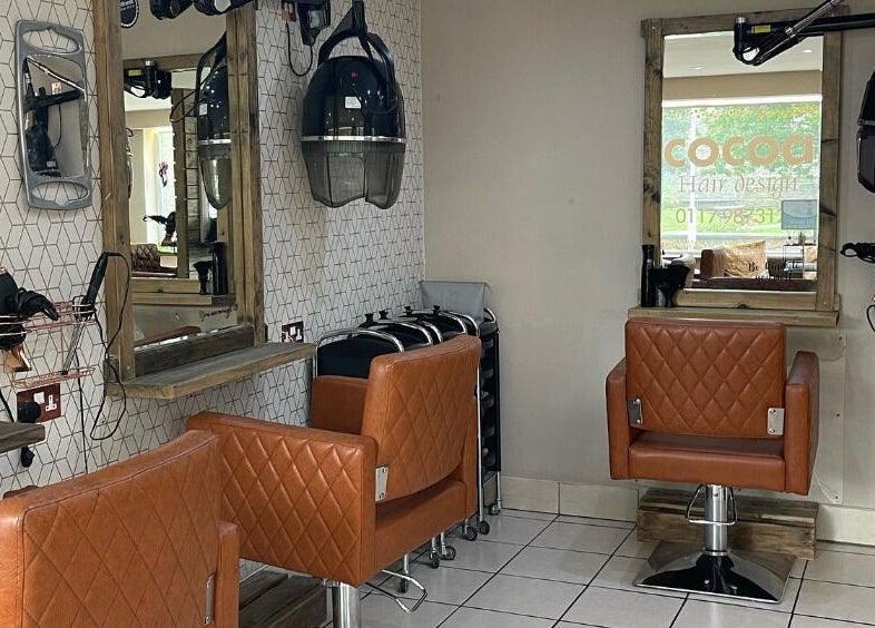Stylish salon stations at Cocoa Hair Design, Keynsham, England, GB with modern leather chairs and mirrors.