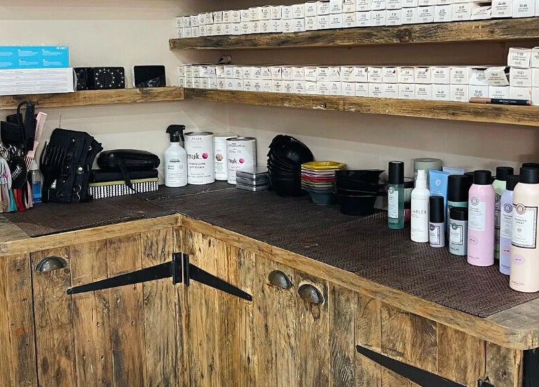 Cocoa Hair Design in Keynsham, England, GB showcases a rustic wooden salon counter with styling products.