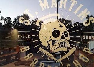 Front window sign of St Martins Barber Shop in Diamond Creek, Victoria, AU with a vintage design.