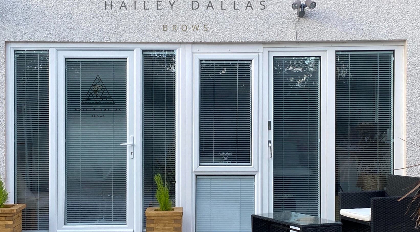 Hailey Dallas Brows in Lhanbryde, Scotland, GB, features a modern glass door entrance with sleek design.