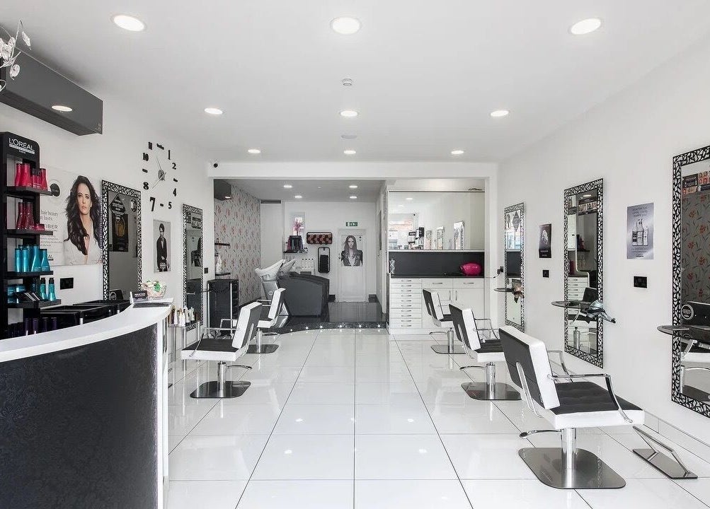 Stylish interior of Reflection Hair Studio in Potters Bar, England, GB with modern decor and elegant chairs.