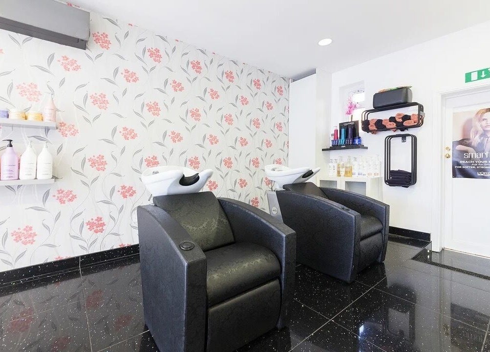 Modern shampoo station at Reflection Hair Studio in Potters Bar, England, GB with stylish chairs and floral decor.
