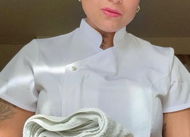 Therapist at Leyla’s Holistic Therapies in St Albans, England, GB holding a towel in a serene setting.