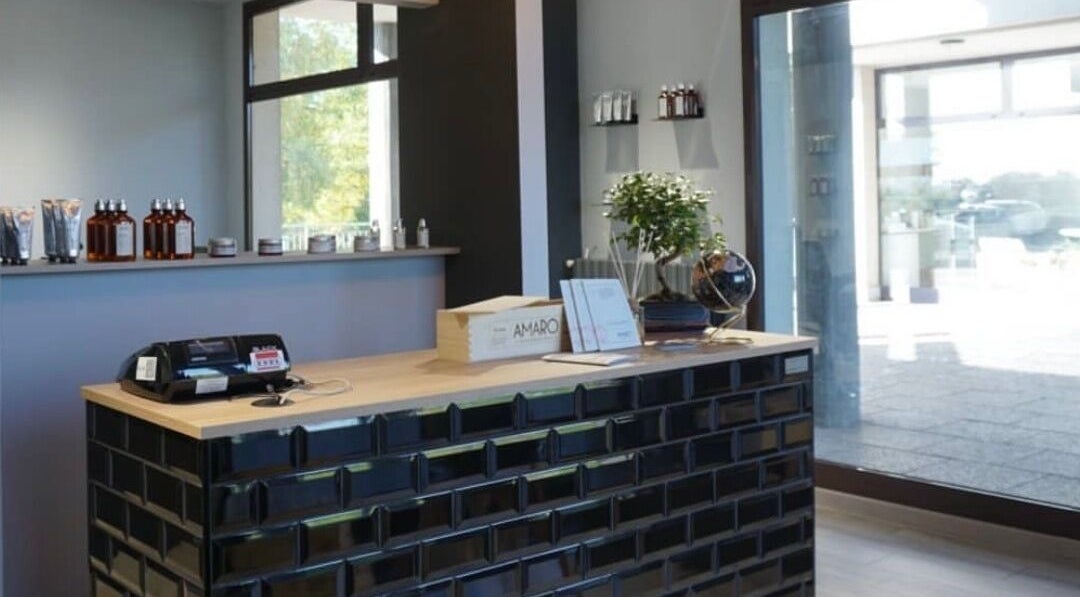 Reception moderna al Blend Barber Studio, Morazzone, Lombardia, IT con dettagli eleganti e prodotti esposti.