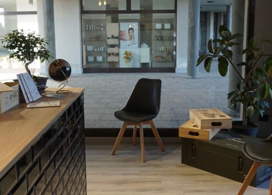 Interno accogliente di Blend Barber Studio a Morazzone, Lombardia, IT con sedie moderne e piante.