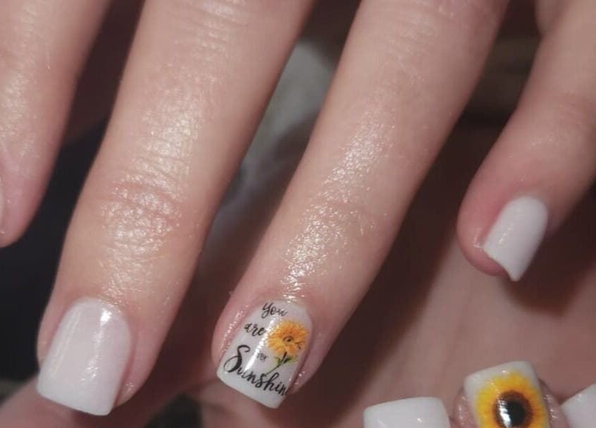 Elegantly styled white nails with sunflower art at The Nail Booth, Krugersdorp, Gauteng, ZA.
