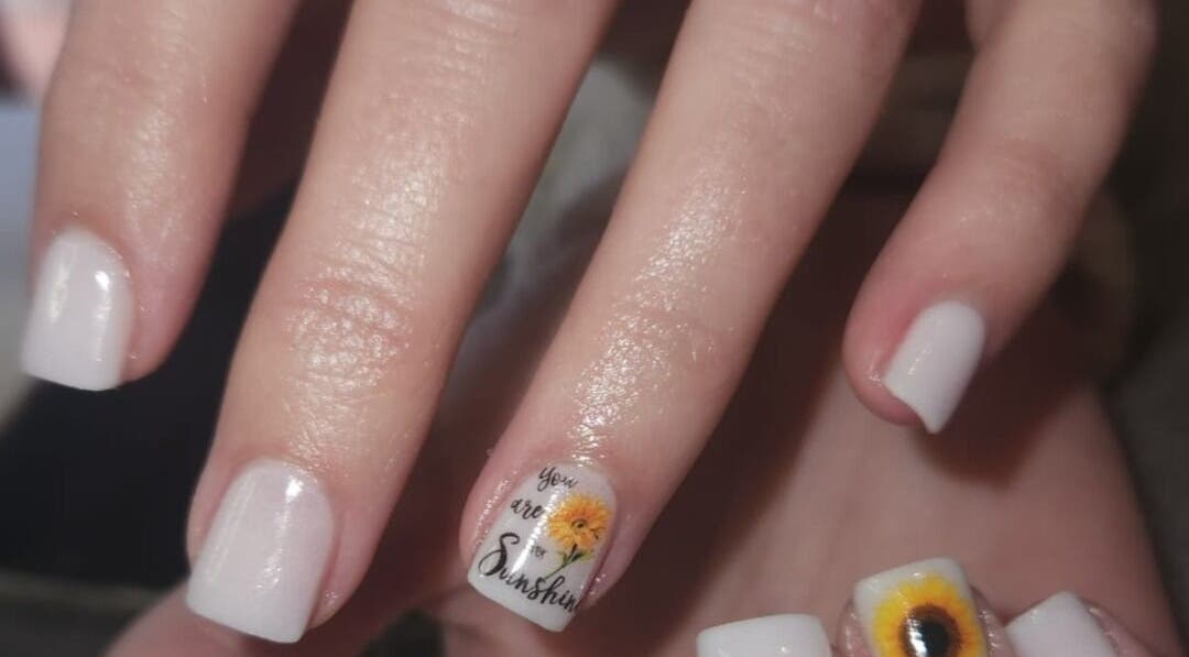 Elegantly styled white nails with sunflower art at The Nail Booth, Krugersdorp, Gauteng, ZA.