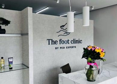 Recepción elegante de The Foot Clinic, Monterrey, Nuevo León, MX, con flores y productos de cuidado.