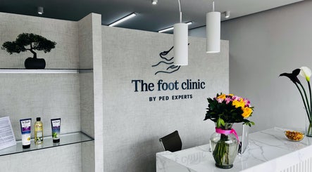 Recepción elegante de The Foot Clinic, Monterrey, Nuevo León, MX, con flores y productos de cuidado.