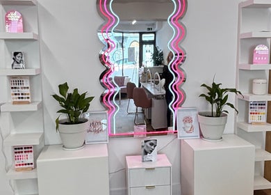Stylish wavy mirror at Savannah Sky Salon, Neyland, Wales, GB, surrounded by sleek decor and vibrant plants.