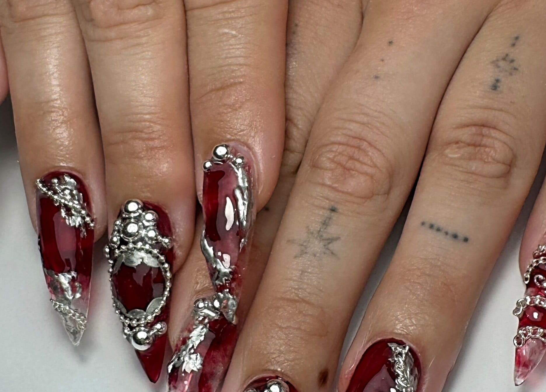 Intricate silver and red nail art design at Gellraiser, Brighton And Hove, England, GB.