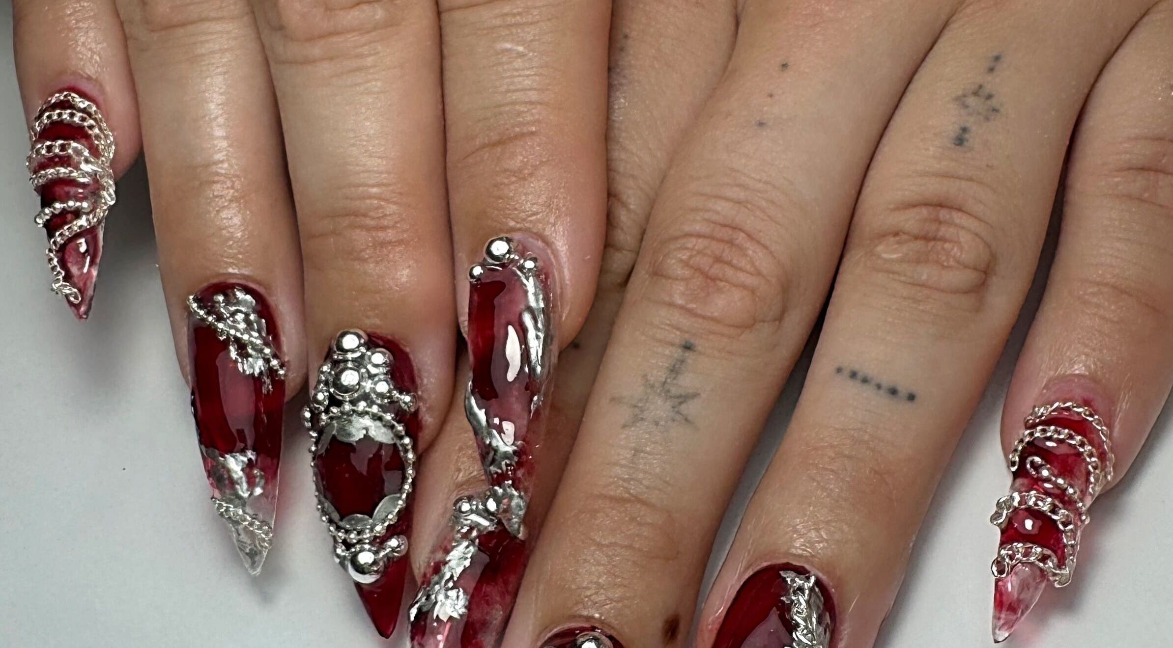 Intricate silver and red nail art design at Gellraiser, Brighton And Hove, England, GB.