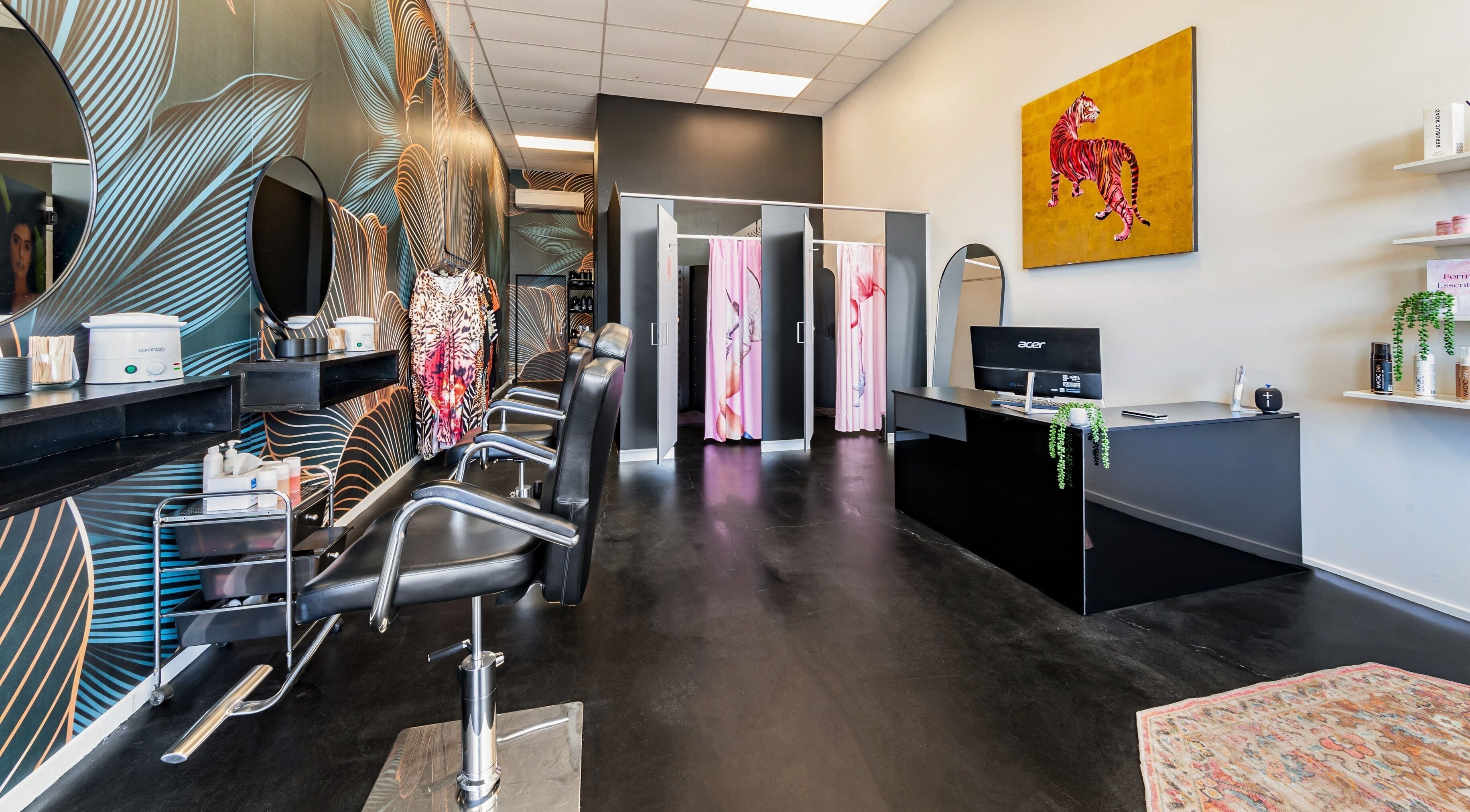 Modern beauty salon interior at Tan in the City Christchurch, featuring elegant chairs and vibrant wall art in Christchurch, Canterbury, NZ.