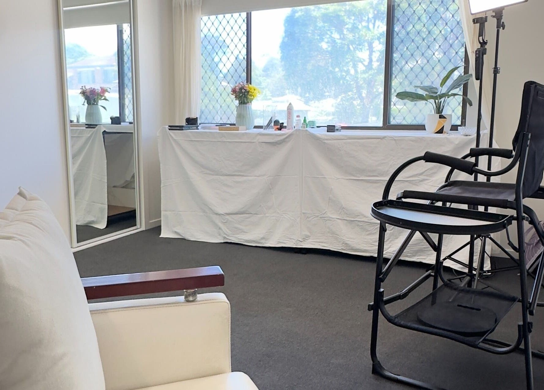 Bright, elegant beauty studio at Dreamy Looks By Kara, Ashmore, Queensland, AU, with makeup chair and large mirror.