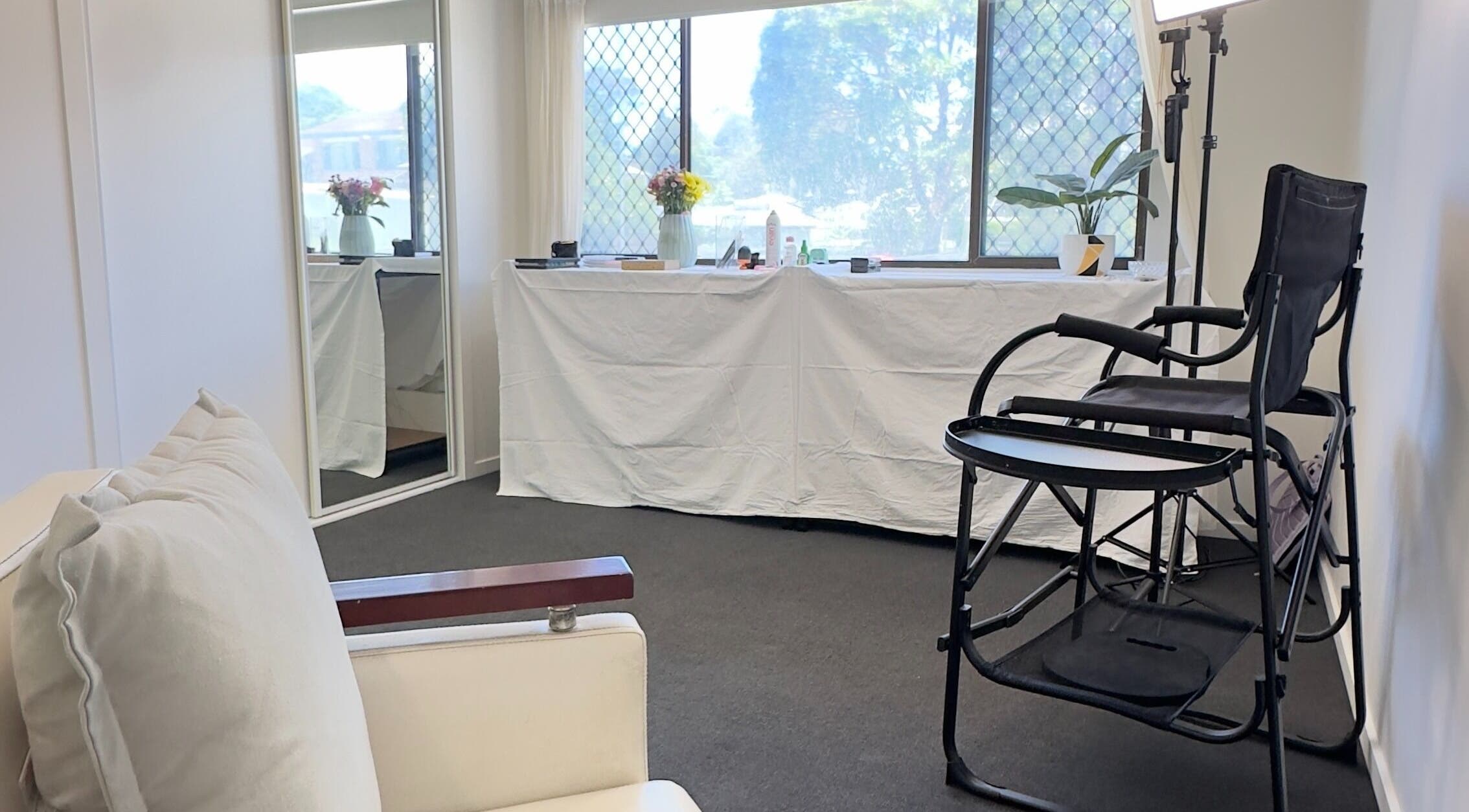 Bright, elegant beauty studio at Dreamy Looks By Kara, Ashmore, Queensland, AU, with makeup chair and large mirror.