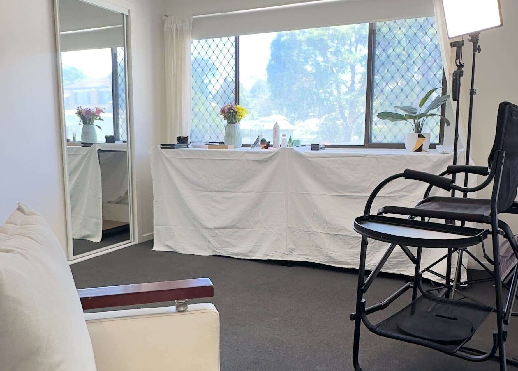 Calm and bright interior of Dreamy Looks By Kara, Ashmore, Queensland, AU. Features a makeup chair and mirror.